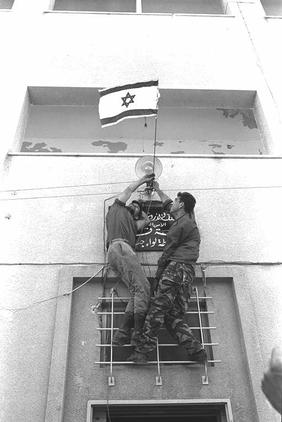  אריה קנפר/לשכת העיתונות הממשלתית,  שני חיילים מניפים את דגל ישראל מעל הכניסה למשטרת ג'נין    , יוני 1967